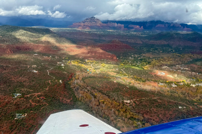 Aerial view of a mountainous landscape with scattered clouds and sunlight patches on the terrain.