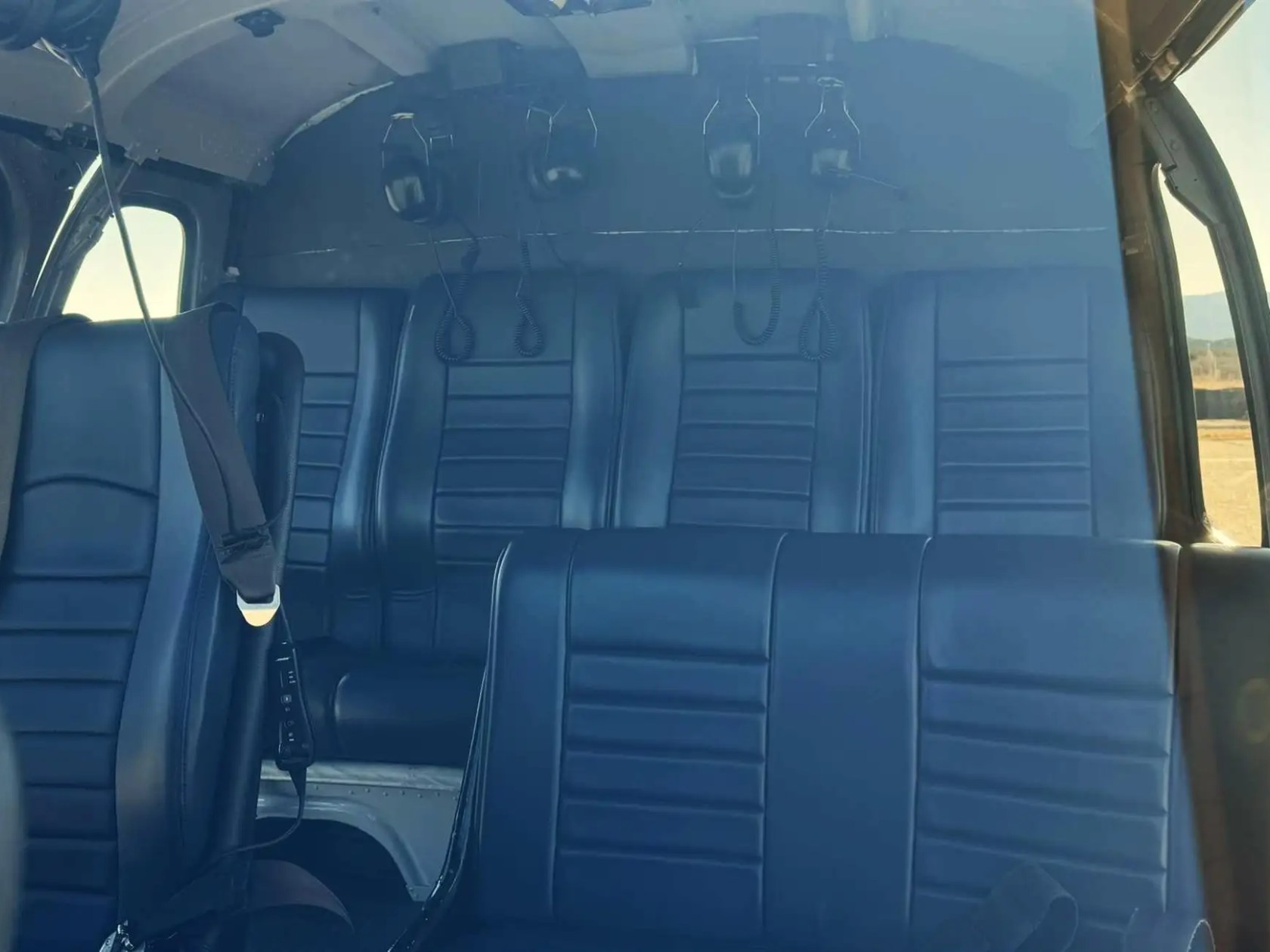 Interior of a helicopter showing empty black leather seats.